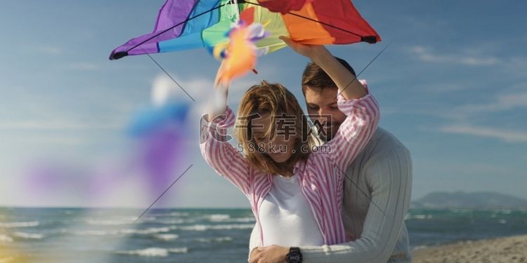 一对情侣在海滩放风筝，在秋天玩
