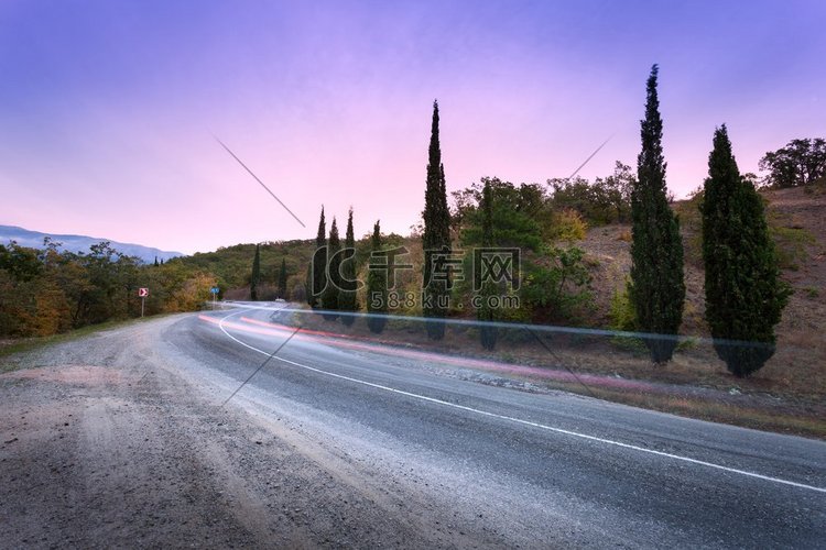 山蜿蜒的道路通过森林与模糊的汽