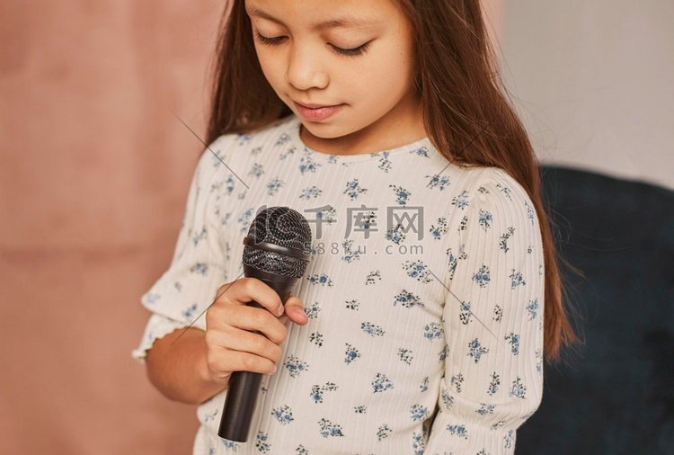 小女孩学习如何唱歌回家与麦克风