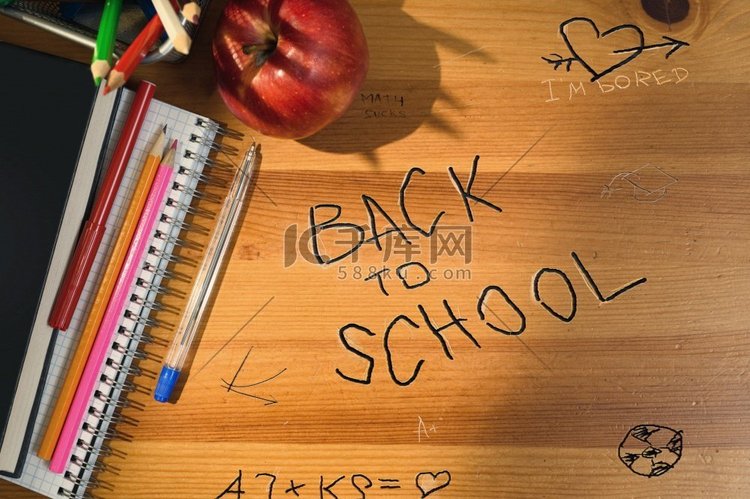 回到学校，在木桌上写字。学校桌