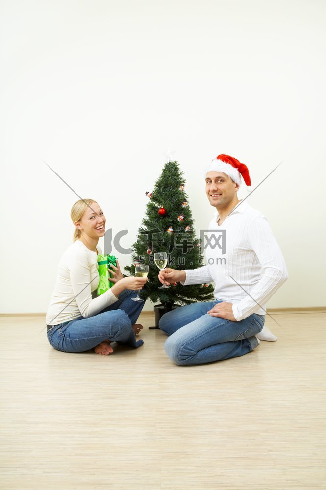 一对快乐的夫妇在圣诞松树上庆祝