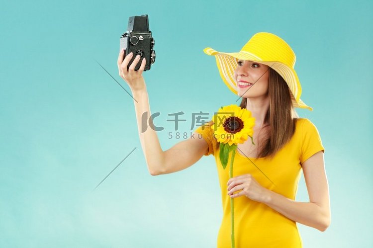夏天妇女穿黄色衣服和帽子与向日
