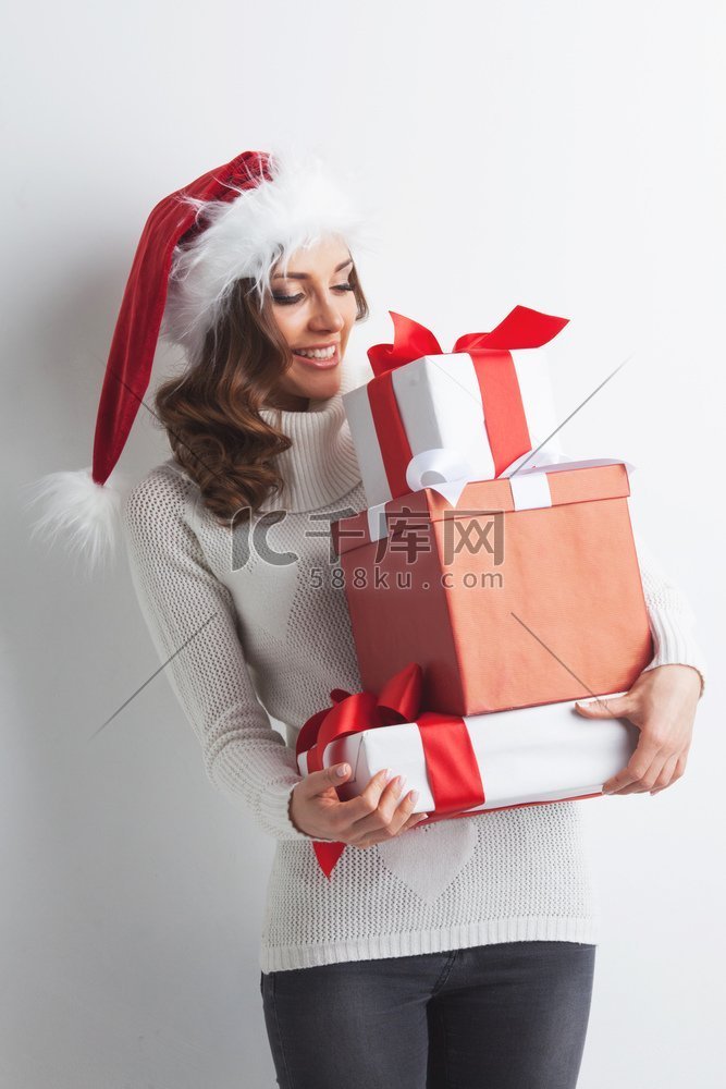 戴着圣诞帽的快乐女人，手里拿着