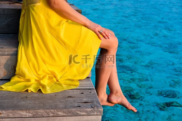 一名穿着黄色连衣裙的女子坐在木