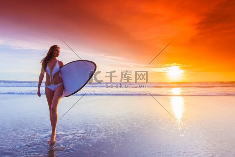 冲浪妇女在海滩日落。美丽的冲浪