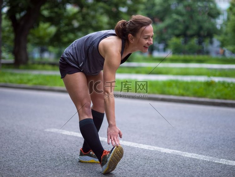 健康女跑步者晨训前在城市公园热