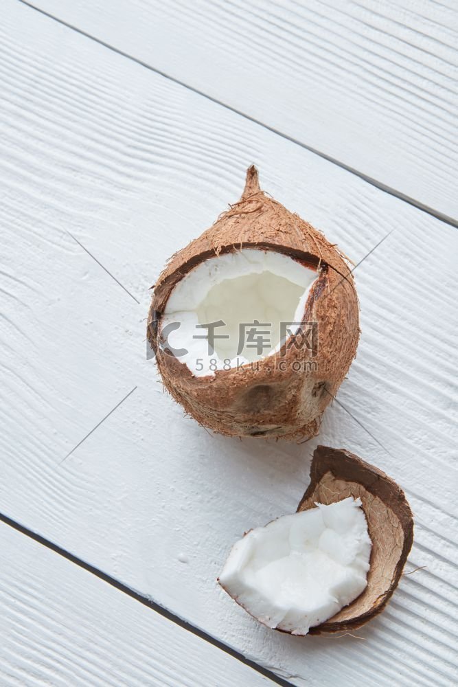 破碎的生熟椰子，孤立在白色木质