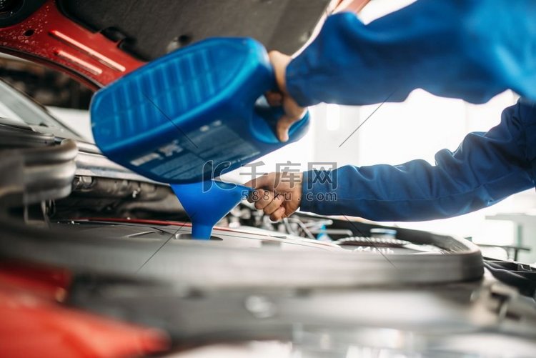 技术员在汽车发动机中更换机油。