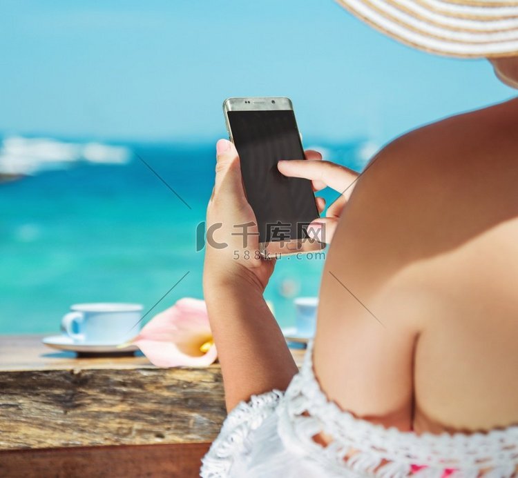 在热带海滩上使用智能手机的放松