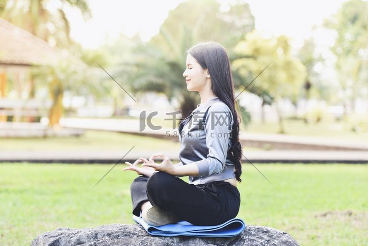 瑜伽妇女年轻的手做瑜伽和放松冥