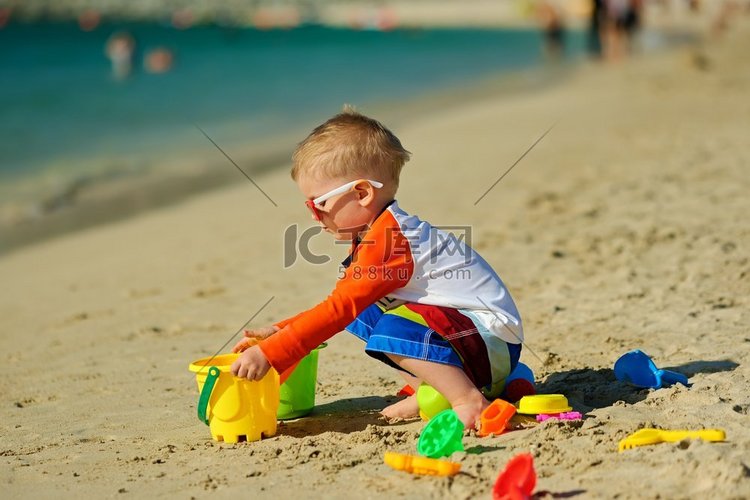 两岁的孩子在沙滩上玩耍。两岁的