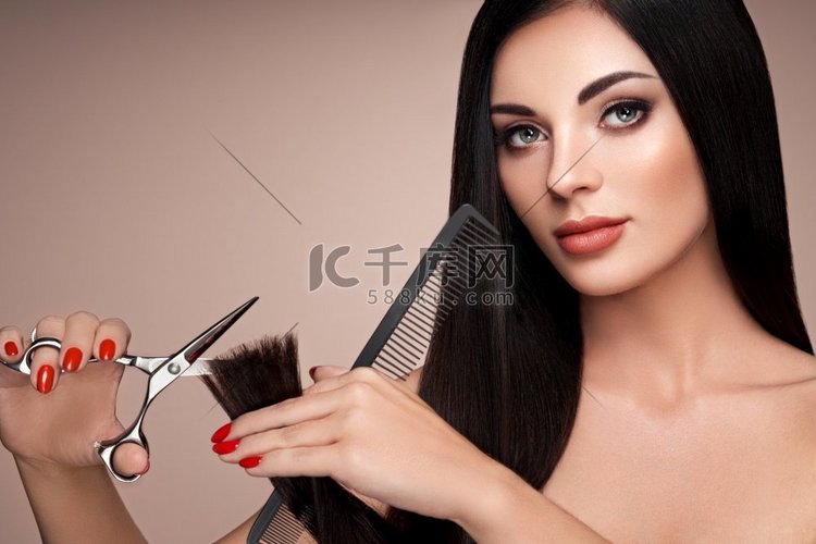 一个年轻的女人剪头发。黑发模特