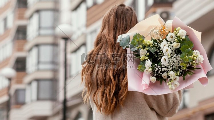 后景优雅的女人在户外拿着花束