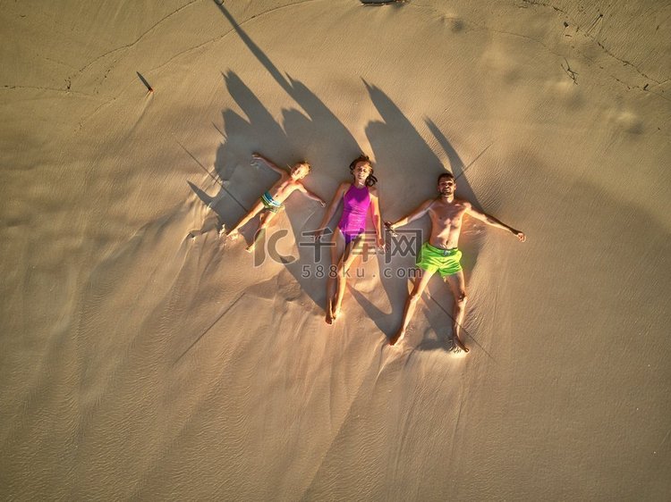 一家人躺在海滩上，俯视无人机拍