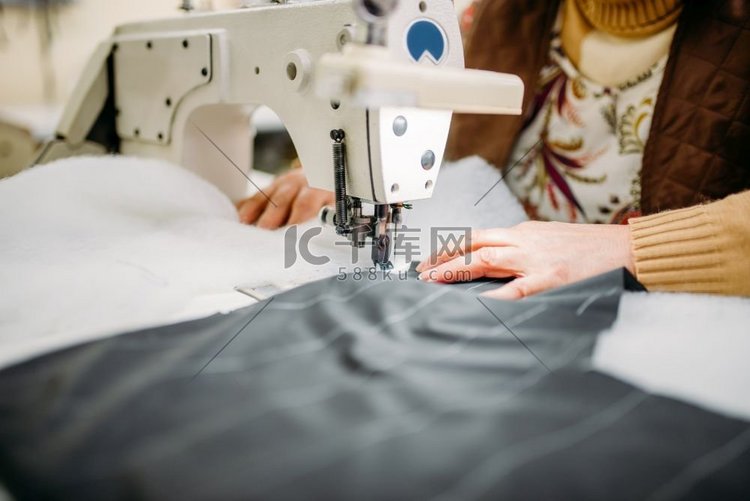裁缝在缝纫机上缝制织物。服装厂