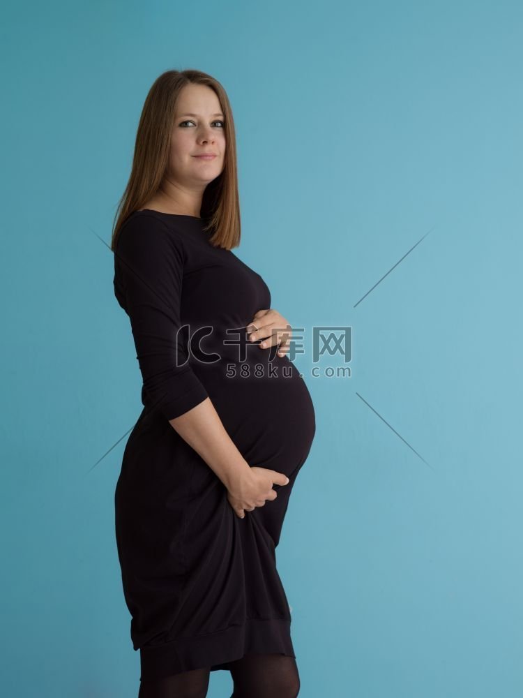 快乐孕妇的肖像，双手放在腹部，