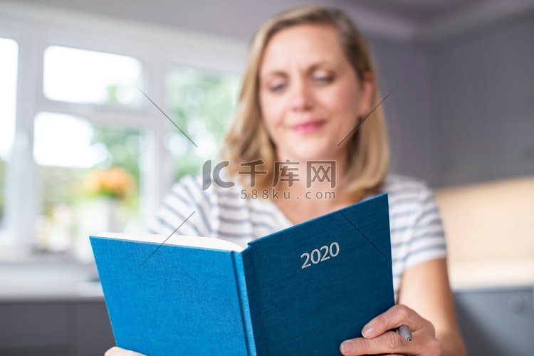 女人打开新年2020日记在家里桌上