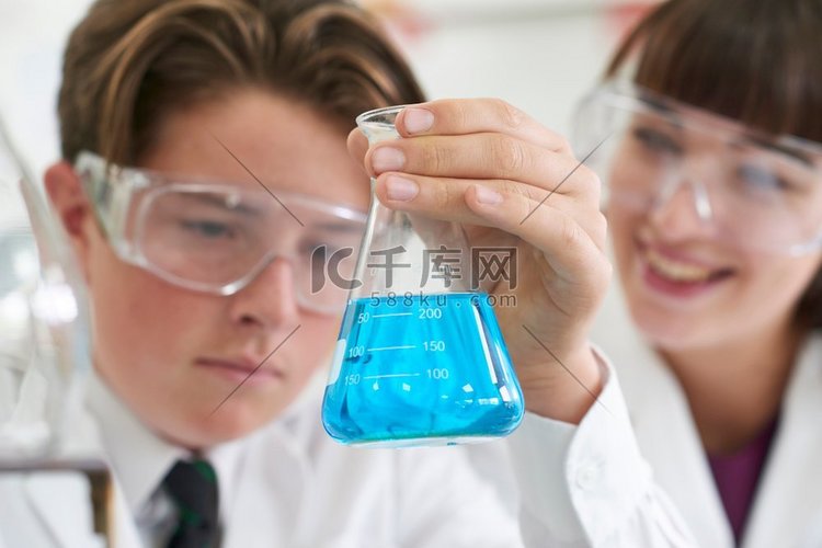 进行化学实验的男学生和男教师