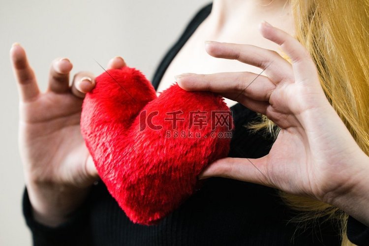 浪漫的女人抱着小红心形状的蓬松