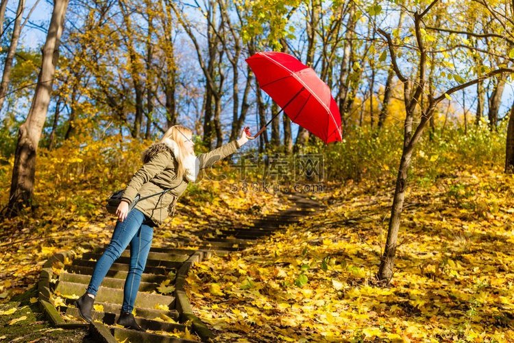 秋天的天气概念妇女走在公园拿着