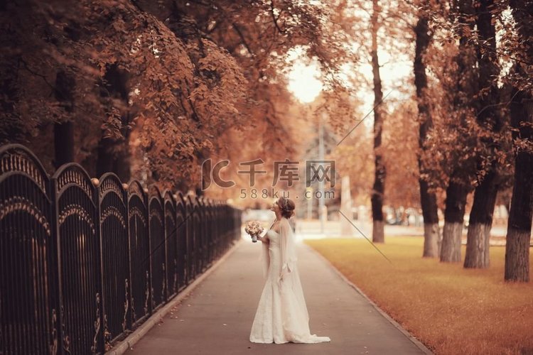 新娘秋天公园在一个白色的礼服，