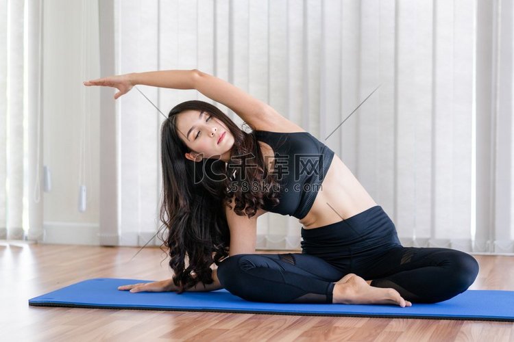 年轻女子练习瑜伽的位置在室内健
