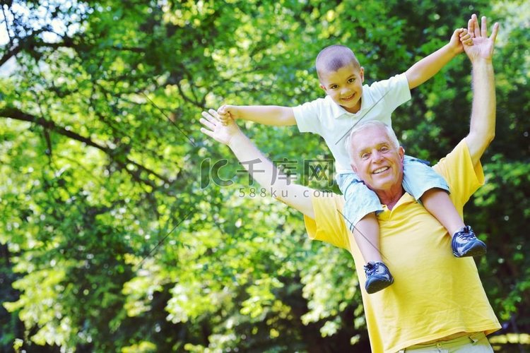 快乐的爷爷和孩子在公园里玩得开