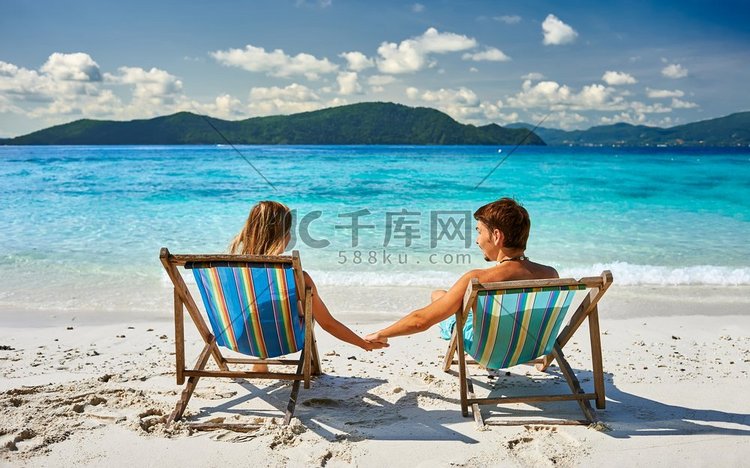 在泰国的热带海滩上的躺椅上的夫