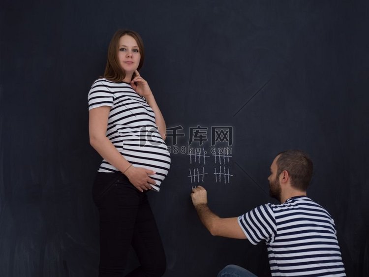 年轻的怀孕夫妇计算怀孕周和写他