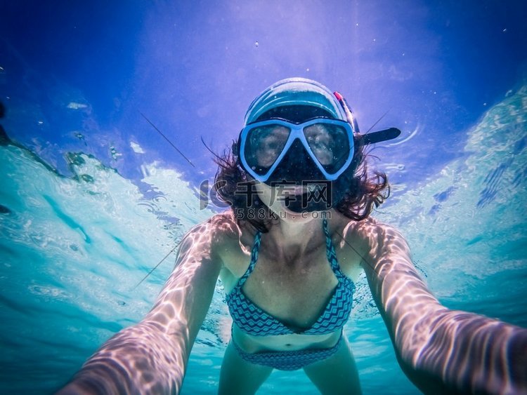 一名女子在清澈的热带海水中浮潜