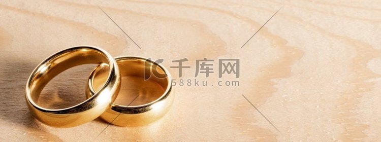两个金结婚戒指在木背景与文本的