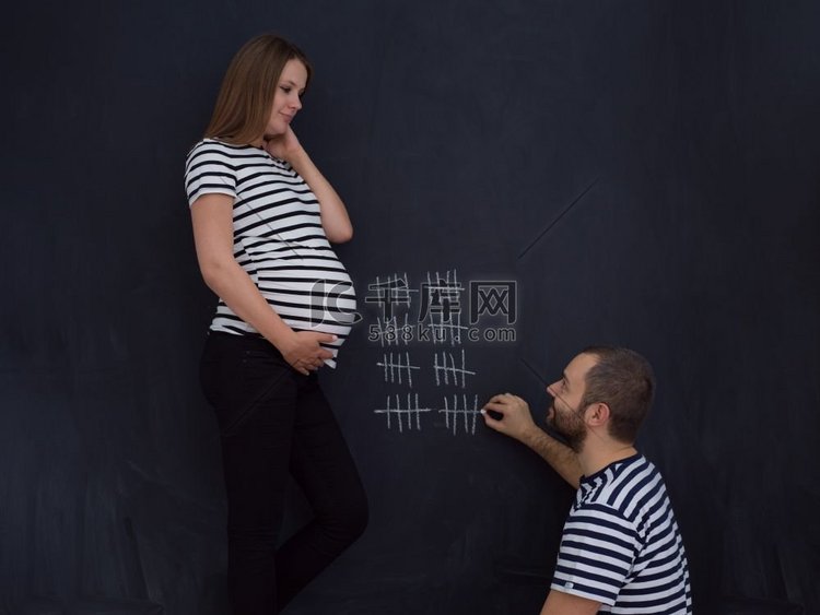 年轻的怀孕夫妇计算怀孕周和写他