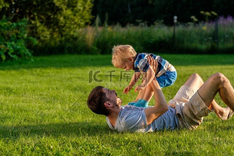 快乐的人和孩子有乐趣在草地户外