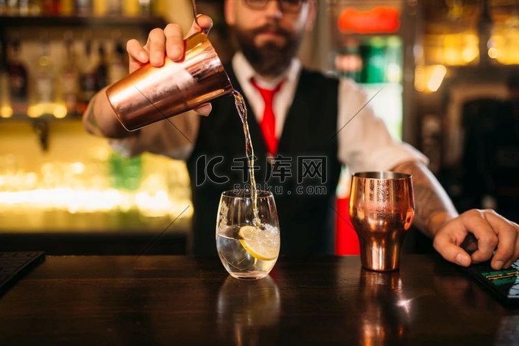 酒保正在吧台上调制酒精鸡尾酒。