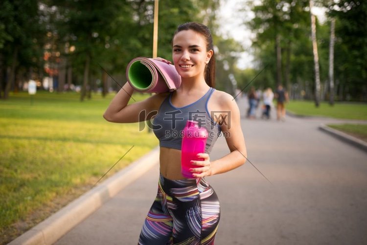 运动女孩与运动瓶在夏季公园。女