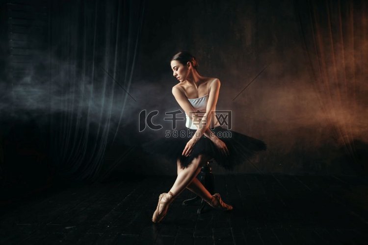 芭蕾舞演员坐在剧院舞台上的黑色