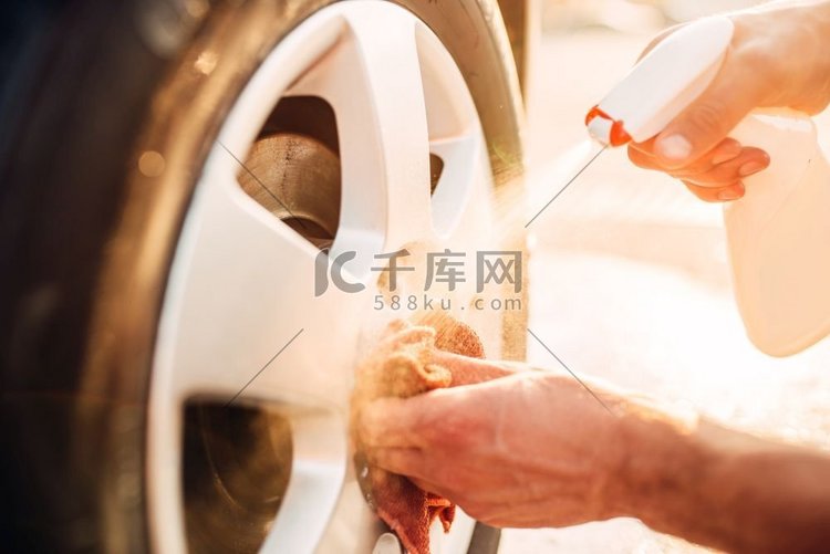 男性手用车边清洁器清洁磁盘，洗
