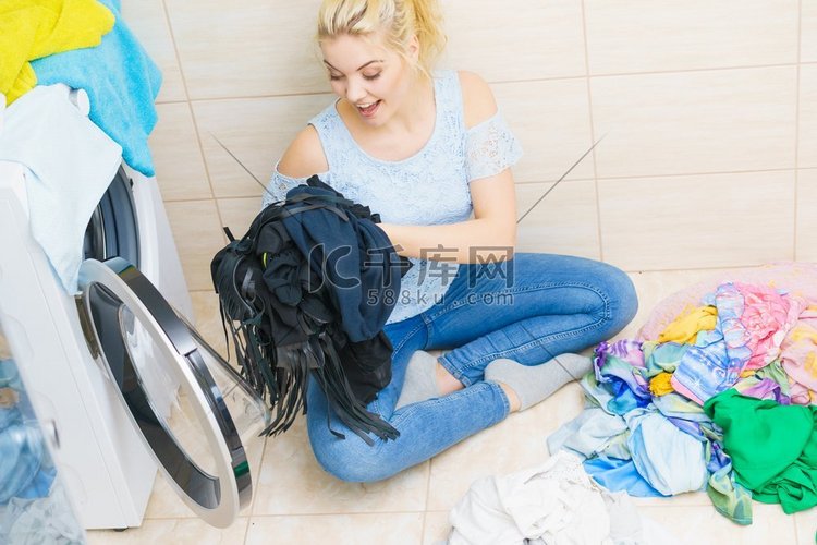 年轻妇女坐在卫生间分类黑色衣服