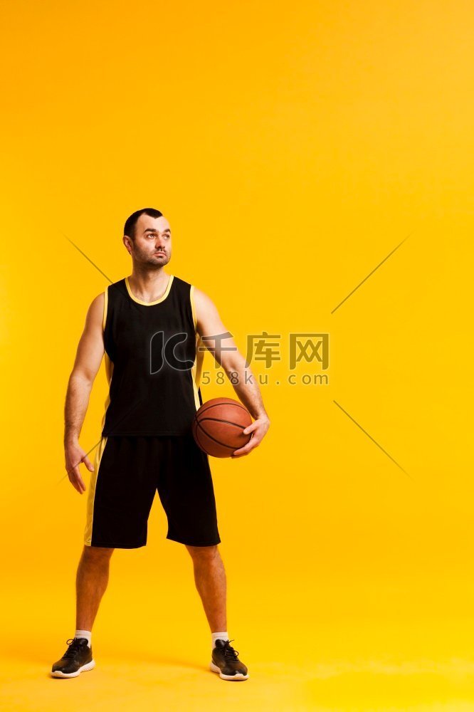 正面视图篮球运动员摆姿势与球关