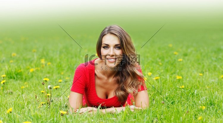 一位年轻漂亮的红衣女子躺在草地