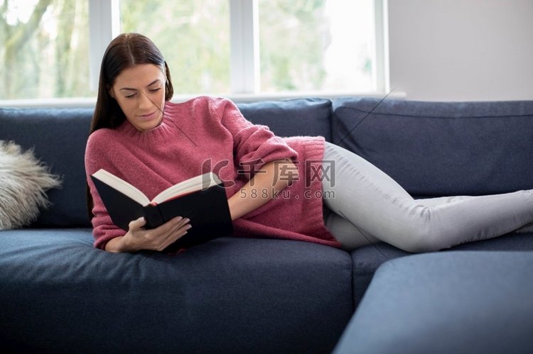 躺在沙发上放松的女人在家看书