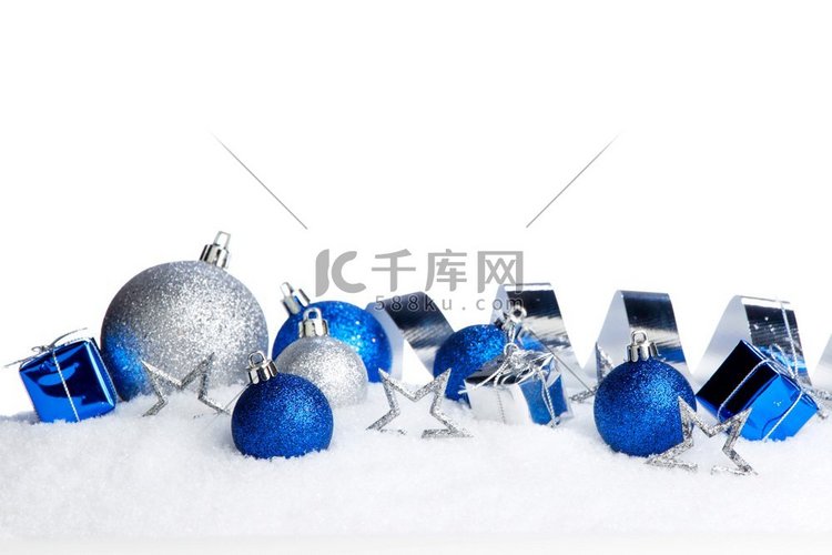 特写雪地上的银色和蓝色圣诞装饰