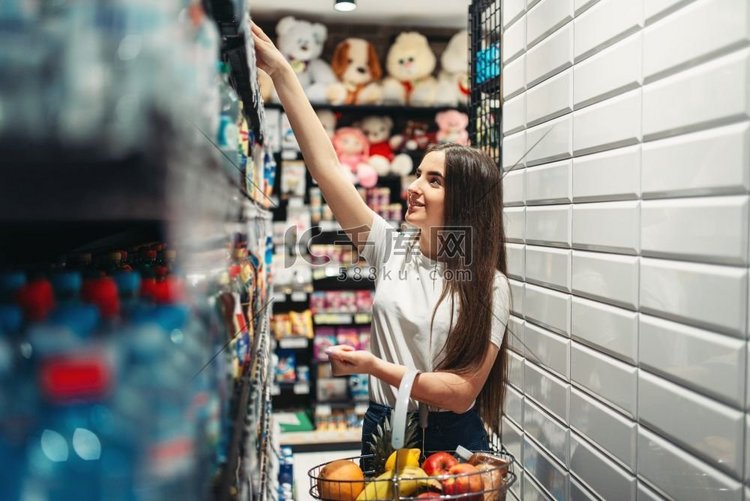 食品店里推着手推车的女顾客。女