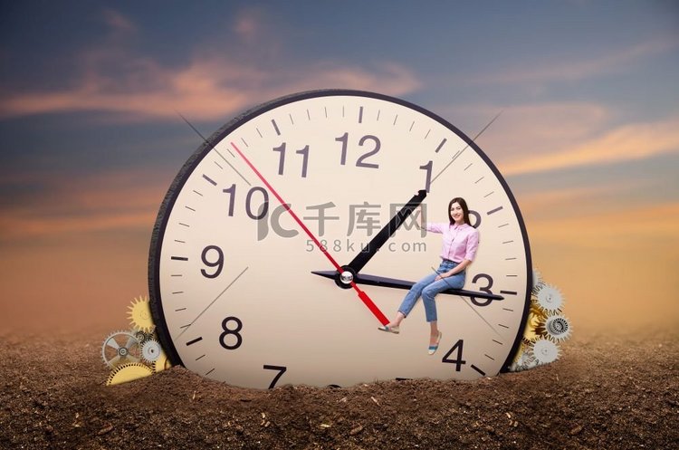 年轻女子坐在一个巨大的时钟箭头