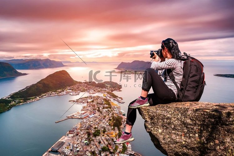 自然摄影师游客站在山顶上用相机