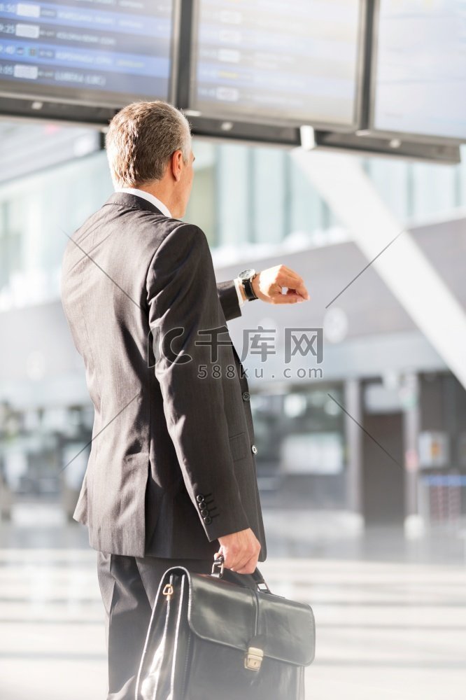 一名商人在机场等待登机时看着手
