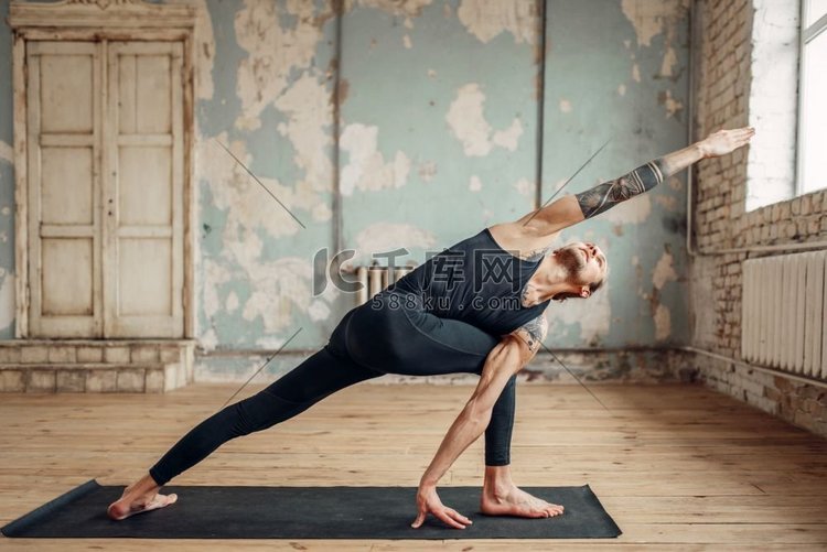 男性瑜伽在室内脏兮兮的健身房里
