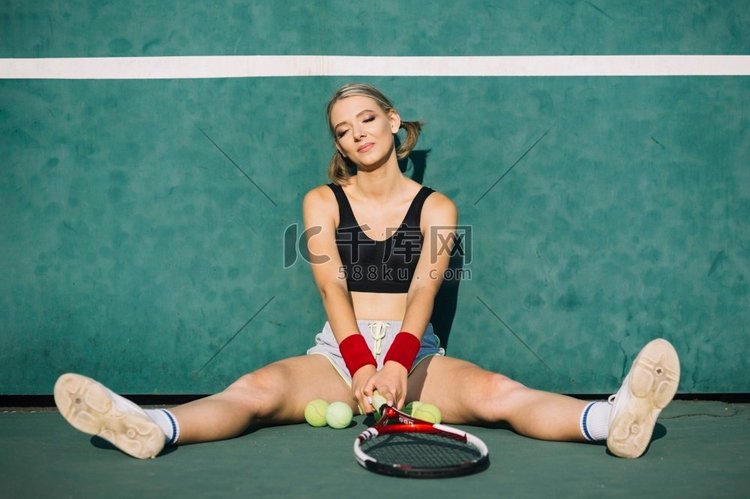 坐在网球场上的美女