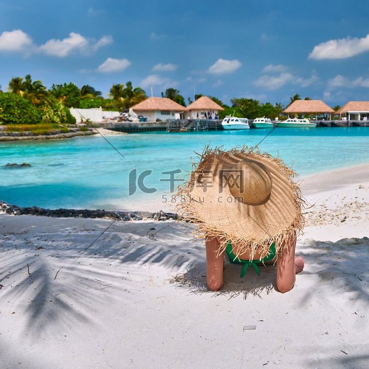 女人坐在海滩下棕榈树。马尔代夫