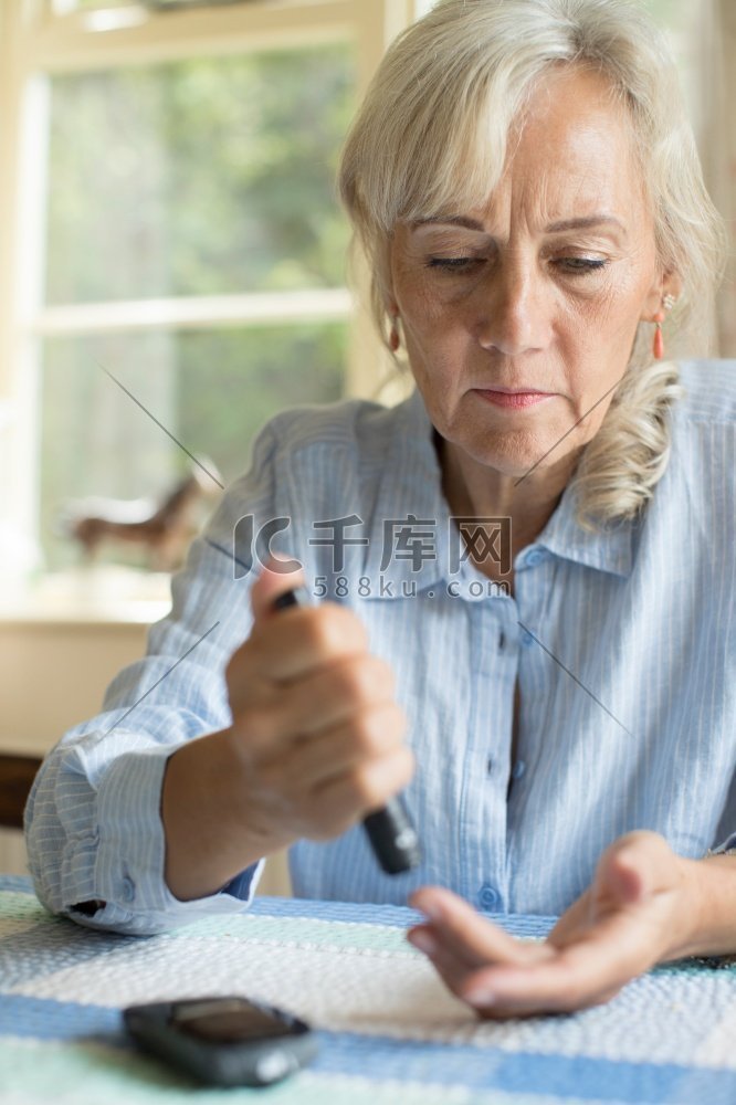 老年糖尿病妇女在家中测试血糖水